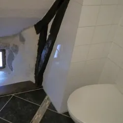 Chambre Twin - Le Clos de Banes : salle de bain avec toilette et mur en pierre.