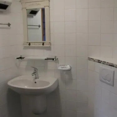 Chambre Quadruple - Le Clos de Banes : salle de bain avec lavabo et miroir.