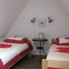 Chambre Quadruple Le Clos de Banes : deux lits simples, table en bois, appliques murales
