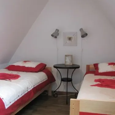 Chambre Quadruple Le Clos de Banes : deux lits simples, table en bois, appliques murales