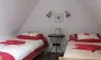 Chambre Quadruple Le Clos de Banes : deux lits simples, table en bois, appliques murales