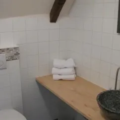 Chambre Luxueuse Le Clos de Banes : salle de bain avec lavabo en pierre, serviettes pliées