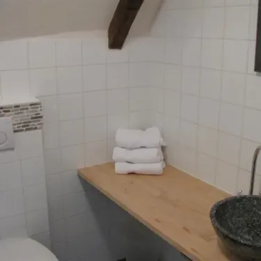 Chambre Luxueuse Le Clos de Banes : salle de bain avec lavabo en pierre, serviettes pliées