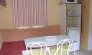 Mobil Home 3 Chambres - 6 personnes - Le Clos de banes : salle à manger avec table, chaises et réfrigérateur