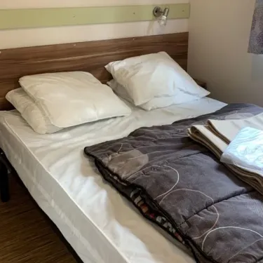 Chambre du mobil home Le Clos de banes avec lit double et couvre-lit