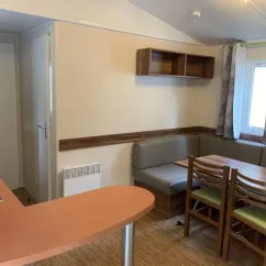 Salle à manger du mobil home Le Clos de banes avec canapé et table