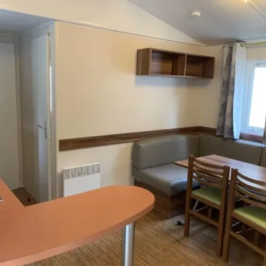 Salle à manger du mobil home Le Clos de banes avec canapé et table