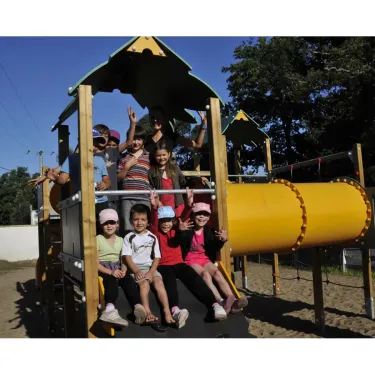 Enfants souriants sur un parc d'attractions en bois au Camping La Pointe