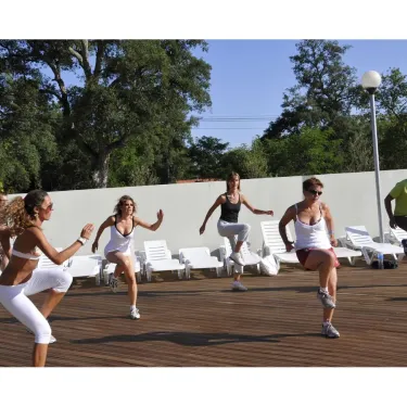 Des femmes font du zumba sur une terrasse en bois au Camping La Pointe.