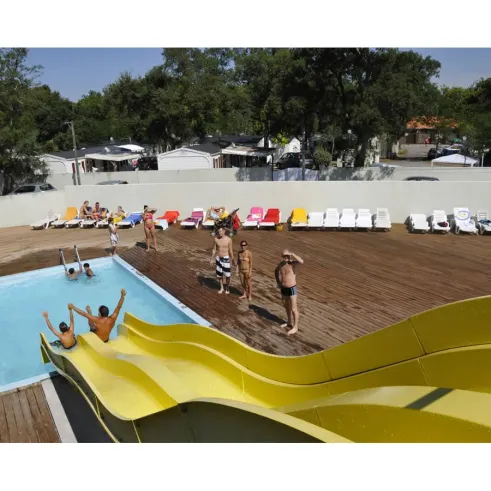 Piscine avec toboggan jaune au Camping La Pointe, enfants jouent dans l'eau.