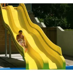 Enfant glissant sur une grande slide jaune dans la piscine aquatique du Camping La Pointe
