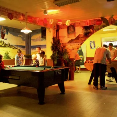 Enfants jouant au billard dans le camping Le Castellas.