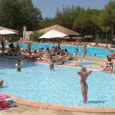 Personnes autour d'une piscine extérieure au Camping Le Castellas
