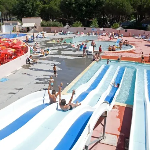 Enfant glissant sur une slide aquatique dans le parc aquatique du Camping Le Castellas.