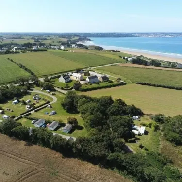 Camping Pré de la Mer avec caravanes et tentes en bordure de champs verts