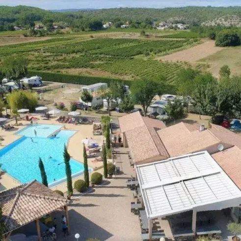 Vue aérienne du Camping de Rouveyrolle avec piscine, caravanes et vignobles environnants.