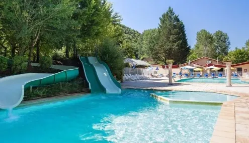 Piscine avec toboggan vert et eau turquoise au Camping Les Bö-Bains.