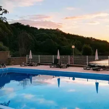 Piscine au coucher du soleil avec reflets dans l’eau, Camping La Romiguière