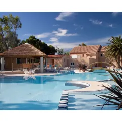 Piscine avec cabane en paille et chaises longues au Camping Le Pré Catalan