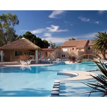 Piscine avec cabane en paille et chaises longues au Camping Le Pré Catalan