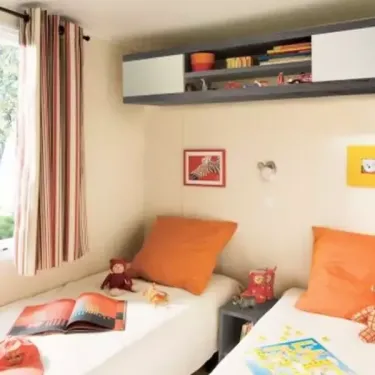 Mobil Home Family 3 Chambres TV - 6 Pers. - Camping le Moténo, chambre avec deux lits et étagères