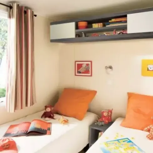 Mobil Home Family 3 Chambres TV - 6 Pers. - Camping le Moténo, chambre avec deux lits et étagères