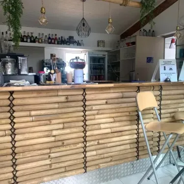 Camping Saint-Lazare - bar en bambou avec tabourets et bouteilles