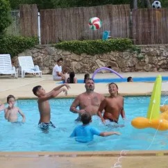 Enfants et adultes jouent au volley-ball dans la piscine au Camping Saint-Lazare