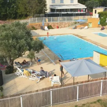 Piscine avec chaises longues et arbre au Camping Saint-Lazare