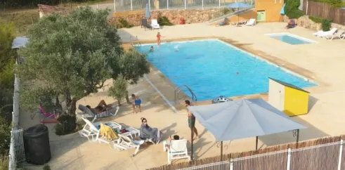 Piscine avec chaises longues et arbre au Camping Saint-Lazare