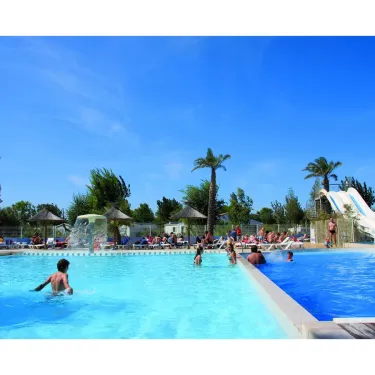 Piscine avec toboggan et palmiers au Camping Mar i Sol