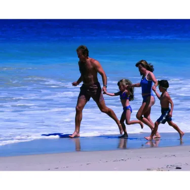 Une famille courant sur la plage à Camping Mar i Sol.
