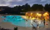 Piscine éclairée avec des enfants nageant au Camping Le Pardaillan