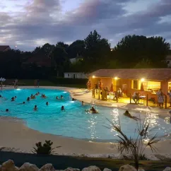 Piscine éclairée avec des enfants nageant au Camping Le Pardaillan