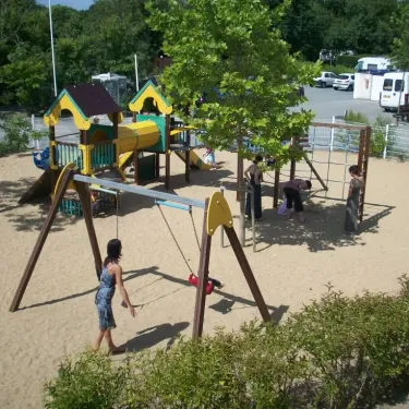 Camping Oléron Loisirs : aire de jeux pour enfants avec balançoire et toboggan en bois.