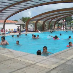 Piscine couverte avec enfants nageant au Camping Oléron Loisirs