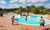Personnes dans la piscine du Camping Les Bois du Bardelet, un homme saute dans l’eau