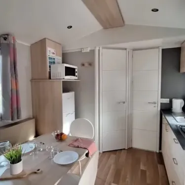 Mobil Home 2 Chambres 4 Pers - Les Rives d'Auzon : cuisine et salle à manger avec micro-ondes