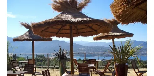 Camping Vigna Maggiore : terrasse avec parasols en paille et vue sur les montagnes