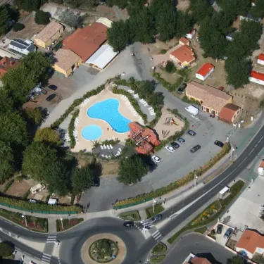 Piscine bleue entourée de chaises longues dans le camping au-dessus d'une route