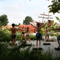 Groupes exécutant des exercices synchronisés sur des plateaux, près d'un bateau décoratif, Camping Village Corsaire