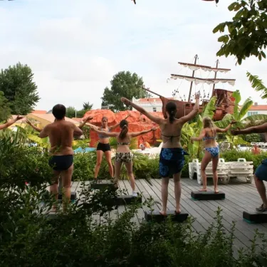 Groupes exécutant des exercices synchronisés sur des plateaux, près d'un bateau décoratif, Camping Village Corsaire