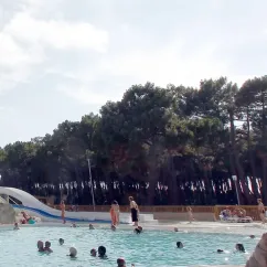 Piscine avec toboggan et personnes nageant au Camping Atlantique Club Montalivet