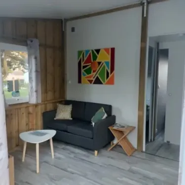 Chalet Bois Tithome 2Ch - 4/5P - Camping de Prigny : salon avec canapé