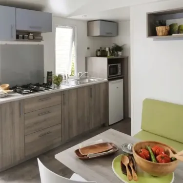 Mobil Home Mercure 2Ch – 4P - Camping du Val : cuisine moderne avec plan de travail et table à manger
