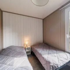 Chambre avec deux lits simples et lampe de chevet - Cottage Premium 3CH - Camping Bel Air Village Les Demeures du Lac
