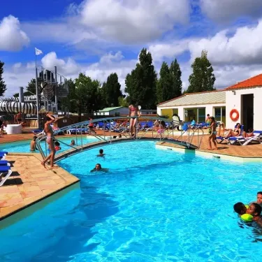 Piscine extérieure avec toboggan et chaises longues au Camping La Bollée d'Air