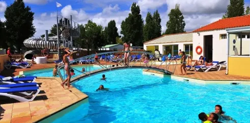 Piscine extérieure avec toboggan et chaises longues au Camping La Bollée d'Air