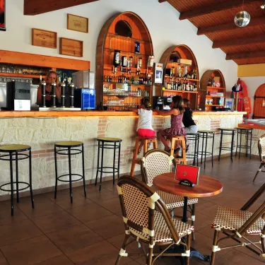 Bar intérieur avec tabourets et tables à Camping La Bollée d'Air