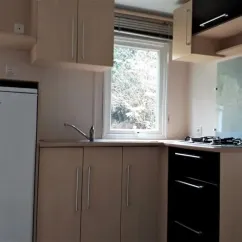 Cuisine équipée avec réfrigérateur, plancha et fenêtre - MH Eco 3CH - Camping Les Rives d'Olt et d'Aubrac